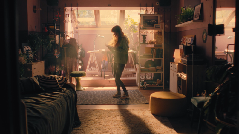 młoda kobieta stojąca w słabo oświetlonym pokoju czytająca książkę