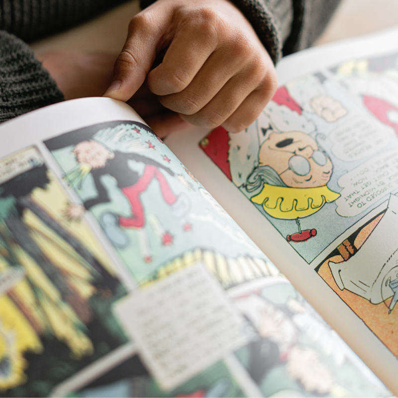 dłoń trzymająca otwarty komiks